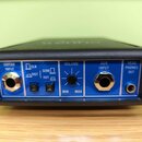 Modrý kompaktní kytarový zesilovač v černém plastovém rámu. Na předním panelu jsou nápisy GUITAR INPUT, CLN, DIST, SEMI, HVY, VOLUME (s označením MIN…