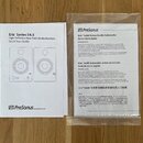 Fotografie zobrazuje dva papírové návody v češtině a angličtině. Levý list nese nadpis Eris Series E4.5 High-Definition Near Field Studio Monitors Qu…