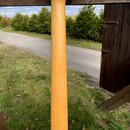 Fotografie zachycuje hmatník a hlavu elektrické kytary z přírodního světlého dřeva. Na hlavě je vidět jeden ladicí mechanismus s kovovým knoflíkem. P…