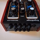 Černý efekt pedál s červeným rámem a stříbrným spínacím tlačítkem. Na horní části je bílý nápis Ringerbringer a označení sekcí RING MODULATOR, MODULA…