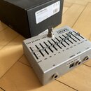 Stříbrný efekt pedál s nápisy MXR a ten band eq. Na horní ploše se nachází deset posuvníků s označením frekvencí od 31 až VOL a regulace GAIN. Na pře…