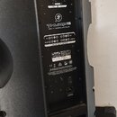 Černý aktivní reproduktor z plastového materiálu. Na zadním panelu je nápis THUMP 15 a text 1000W 15" POWERED LOUDSPEAKER. Panel obsahuje ovládací pr…
