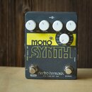 Šedý efekt pedál s žlutým nápisem MONO SYNTH. Na horní části jsou čtyři bílé oválné knoflíky s popisky DRY VOL, SYNTH, SENS a CTRL. Uprostřed je jede…