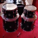 Sada černých bubnů s chromovaným kováním. Na basovém bubnu je bílý nápis SONOR a na ostatních bubnech jsou viditelné loga značky Sonor. Nástroje jsou…