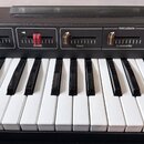 Detailní pohled na klávesnici s černým ovládacím panelem. Na panelu jsou umístěny posuvníky s popisky SUSTAIN, LONG, SUSTAIN, SUMME, PIANO a sekce PE…