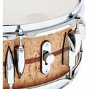 Detailní pohled na snare drum s korpusem z pleteného dřeva v přirozené barvě a tmavým horizontálním pruhem. Nástroj má chromované obruče, šrouby a la…