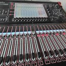 Černý digitální mixovací pult s červenými detaily na hranách. V horní části je nápis DiGiCo SD9, displej a ovládací prvky. Spodní část obsahuje velké…