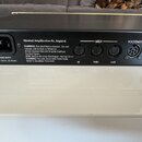 Zadní strana černého kytarového zesilovače s bílými nápisy. Jsou zde konektory MAINS INPUT (230V - 50 Hz, 20 Watts), tři MIDI konektory s označením I…