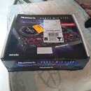 Fotografie znázorňuje uzavřenou kartonovou krabici s DJ kontrolérem. Na obalu je uveden název značky Numark a model PARTY MIX LIVE, dále nápis serato…