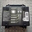 Zadní strana černého plastového kufříku s produktovou informací o mikrofonu. Na obalu je vidět fotografie stříbrného mikrofonu a text v sekci SPECIFI…