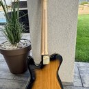 Zadní strana elektrické kytary s tělem v provedení sunburst a světlým krčkem. Na hlavě jsou zlaté ladičky a nápis "Custom Shop". Kytara má zlatý kryt…