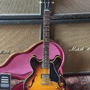 Polodublová elektrická kytara s tělem v žlutě-hnědém sunburst provedení a černým pickguardem. Na hlavě hředu je viditelné logo Gibson. Kytara má dva…