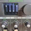 Detail ovládacího panelu mixeru s displejem a knoflíky. Na displeji je nápis SPEAKER CONTROL a čtyři kanály označené 1, 2, BT, U. Pod displejem jsou…