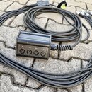 Černý rozbočovací kabel s plastovým rozdělovačem. Na přední straně rozdělovače jsou čtyři konektory XLR a nad nimi nápisy 01., 02., 03. a 04. Kabel j…