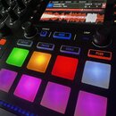 Detailní pohled na ovládací panel DJského kontroléru v černé barvě. Na displeji je zobrazen waveform a text „POČKEJ w8“, „Yzomandias - Topic“ spolu s…
