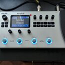 Bíle provedený multifunkční efektový procesor s nápisem MK-300 a logem M-VAVE. Zařízení má digitální displej, na kterém je zobrazen text 006 Spring W…