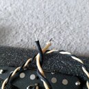 Fotografie zachycuje elektrický snímač s černým plastovým krytem a šesti viditelnými kovovými póly. Ze snímače vedou dva opletené vodiče v černé a kr…