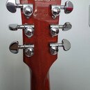 Zadní strana hmatníku kytary z reddish-brown dřeva s lakovaným povrchem. V horní části je vyrazeno sériové číslo 281410267 a nápis MADE IN USA. Nástr…