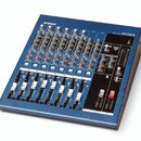 Modrý mixážní pult s kovovým šasi a černým ovládacím panelem. V horní části je bílé logo YAMAHA a vpravo nápis MG12/4. Zařízení obsahuje řadu regulač…