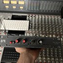 Černý rackový kompresor s nápisem COMPRESSOR LIMITER a logem DB R. Přední panel obsahuje dva červené ovratové knofíky s označením output a input, tři…