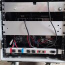 Fotografie zachycuje zadní část transportního racku na kolečkách, v němž jsou osazena elektronická zařízení. Na horním přístroji je vidět nápis ALESI…