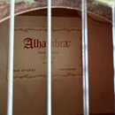 Fotografie zachycuje vnitřek akustické kytary s viditelným štítkem na lícové desce. Na štítku je červeným písmem nápis Alhambra, pod ním text Made in…