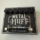 Černý efekt pedál s bílými nápisy. Na horní části jsou šest ovládacích knoflíků s popisky VOL, TOP BOOST, MIDDLE, BASS a DIST. Uprostřed je velký náp…