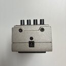 Kryt efektového pedálu v stříbrné barvě s matným povrchem. V horní části jsou vidět pět černých oválných knoflíků. Na přední straně jsou umístěny dva…