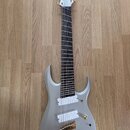 Šedá elektrická kytara s matným povrchem a šesti strunami. Na hlavě hmatníku je bílé logo "Schecter". Nástroj má dva bílé humbuckery, zlatý most a je…