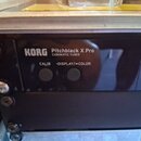 Černý chromatický tuner s nápisy KORG, Pitchblack X Pro a CHROMATIC TUNER. Na předním panelu jsou dvě kulatá tlačítka s popisky CALIB a DISPLAY/-COLO…