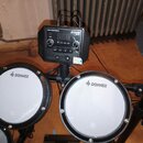 Elektronická bicí souprava s černým modulem, na kterém je nápis DRUM SOUND MODULE a logo DONNER s označením DED-10. Modul obsahuje digitální displej,…