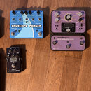 Fotografie zobrazuje pět efektových pedálů na dřevěné podlaze. Modrý pedál nese nápisy ENVELOPE PHASER, Moontone a SPEED PEDAL 1. Fialový pedál se sk…