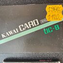 Černá papírová krabička s nápisem KAWAI CARD a menším označením RAM. Na pravé straně je zelený nápis DC-8 a žlutá cenová nálepka s přeškrtnutou hodno…
