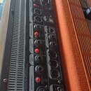 Fotografie zachycuje zadní panel černého elektronického zařízení s řadou konektorů a přepínačů. Jsou zde viditelné nápisy MAIN OUTPUT, MONITOR OUTPUT…