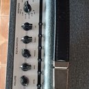 Detailní pohled na ovládací panel kytarového komba v šedé barvě s nápisem SILVERLINE. Panel obsahuje řadu otočných potenciometrů pro Master, Resonanc…