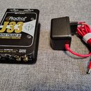 Černý phono předzesilovač s kovovým povrchem a nápisy Radial engineering, J33, PHONO PREAMP DI a RIAA TURNTABLE EQUALIZED. Na předním panelu jsou pře…