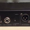 Zadní strana černého rackového zařízení s několika konektory. Jsou zde viditelné nápisy BALANCED OUTPUT, UNBALANCED OUTPUT a INSTRUMENT LINE u jednot…