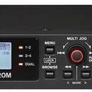 Černý rackový digitální záznamový zařízení s nápisem TASCAM a označením modelu SD-20M. Přístroj má LCD displej, ovládací prvky včetně červeného Multi…