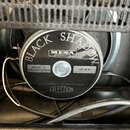 Fotografie zachycuje zadní stranu reproduktoru v černém provedení. Na středovém krytu jsou nápisy BLACK SHADOW, logo MESA ENGINEERING a text MADE ESP…