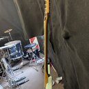 Fotografie zachycuje elektrickou kytaru z profilu, je vidět hmatník, krk a část světle šedého trupu. Kytara má dřevěnou barvu krku a hlavy, na které…