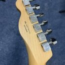 Zadní strana hlavy kytary z přírodního dřeva s šesti chromovanými ladicími mechanismy. Na každém mechanismu je vyryto logo Fender. Na dřevě je černý…