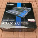 Krabice s míchací konzolí značky YAMAHA, model MG16XU. Na balení je fotografie černého mixážního pultu a nápisy CUBASIS LE a iPad Connectivity. Krabi…