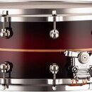 Kytarový snare drum v tmavě červeném odstínu s horizontálním světle hnědým pruhem uprostřed korpusu. Nástroj má chromované obruče a napínací šrouby,…