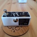 Bílý kytarový efekt s černým horním panelem. Na panelu je bílý nápis „Super Clean by Xotic USA“ a označení „GAIN“ u ovládacího prvku. Na spodní stran…