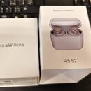 Dvě bílé krabice od sluchátek. Na obou je nápis Bowers & Wilkins, na pravé krabici je navíc obrázek růžových sluchátek v nabíjecím pouzdře a nápis Pi…