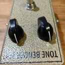 Kytarový efekt v béžovém šasi s texturovaným povrchem. Na horní straně jsou dva černé otočné knoflíky a jeden kovový spínací pedál. V dolní části je…