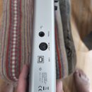 Detail zadní strany stříbrného hudebního zařízení s konektory. Jsou zde viditelné porty s popisky PEDAL, MIDI OUT a USB. Dole je uveden text: Thomann…