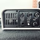 Bíle provedené zařízení s černým předním panelem. Panel obsahuje tři otočné ovladače s nápisy OUT LEVEL, VOICING a SPACE, přepínač IN LEVEL s poloham…