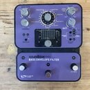 Fialový efekt pedál s nápisem soundblox® PRO BASS ENVELOPE FILTER a logem SOURCE AUDIO. Zařízení má několik ovládacích knoflíků, přepínačů a v horní…