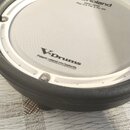 Bílá mesh membrana elektronického bubnu s černým plastovým rámem. Na povrchu je vidět logo Roland a nápis MESH HEAD Reg. U.S. Pat. & Tm. Off. níže je…